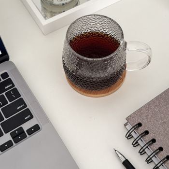 Laptop, glass mug of tea, and spiral notebook on a white desk — a cozy workspace setup for homepage copywriting