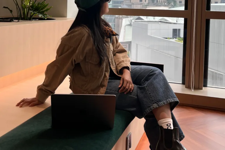 Online service provider sitting with laptop in a modern coworking space