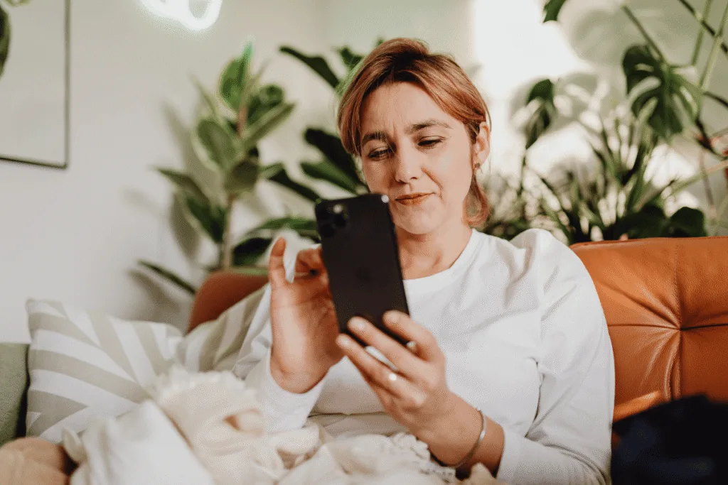 Woman relaxing on a couch scrolling on her phone — representing how potential clients search for service based businesses on Google