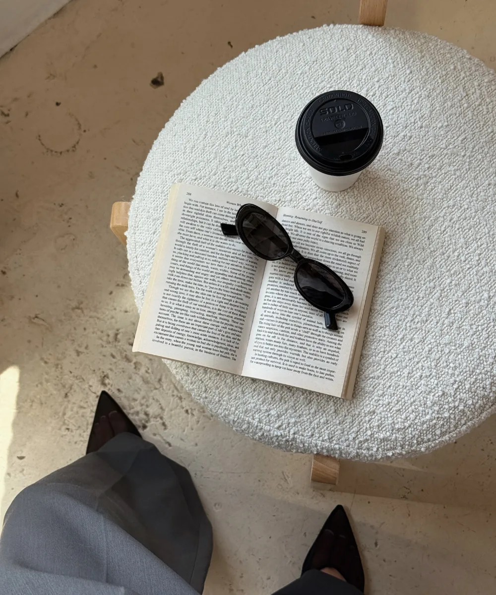 Flat lay of an open book, sunglasses, and coffee on a white surface — representing the strategy behind every copy template