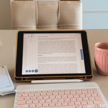 Gold laptop and pen on a white desk — what to include on a services page to book more clients