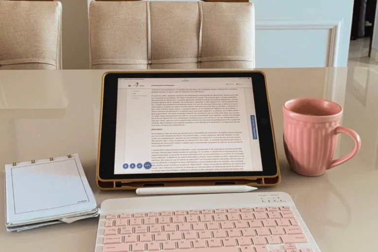 Gold laptop and pen on a white desk — what to include on a services page to book more clients
